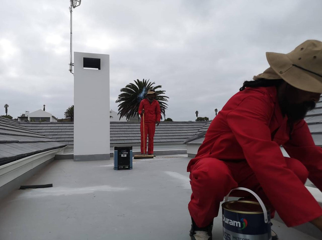 Technicians applying waterproof roof coating